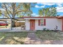 Front view of house with carport and red door at 5711 S Coolidge Ave, Tampa, FL 33616