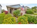 House exterior with walkway, lush landscaping, and American flag at 6516 Salt Creek Ave, Apollo Beach, FL 33572