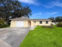 Charming single story home with a spacious lawn and attached garage at 12233 Bartkus Ct, Hudson, FL 34669