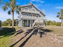 Two-story house exterior with elevated deck and surrounding palm trees at 1614 Sea Breeze Dr, Tarpon Springs, FL 34689