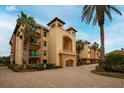 Mediterranean-style building with brick pavers and palm trees at 1695 Pinellas Bayway S # D1, Tierra Verde, FL 33715