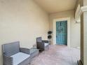 Front entry with teal door, two wicker chairs, and a brick floor at 17523 Stinchar Dr # 17523, Land O Lakes, FL 34638