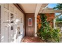 Front entrance with double doors, brick accents, and lush landscaping at 3614 Rock Royal Dr, Holiday, FL 34691