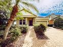 One-story house with a light brown exterior, landscaping, and a brick driveway at 5308 Sanderling Ridge Dr, Lithia, FL 33547