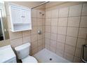 Clean bathroom with shower, grab bar, and white cabinet at 7323 Belvedere Ter, New Port Richey, FL 34655