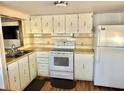 Efficient kitchen featuring white appliances and wood-look flooring at 9790 66Th N St # 312, Pinellas Park, FL 33782