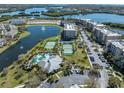 Community view with pool, tennis courts, and lake at 7069 Key Haven Rd # 504, Seminole, FL 33777