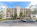 Tan three-story building with balconies and parking at 7069 Key Haven Rd # 504, Seminole, FL 33777