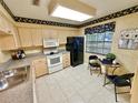Bright kitchen with white appliances and breakfast nook at 2119 Elm St # 101, Dunedin, FL 34698