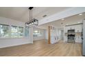 Open concept dining area with modern light fixture and wood flooring at 8462 8Th N Way, St Petersburg, FL 33702