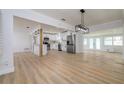 Open concept dining area with modern light fixture and wood flooring at 8462 8Th N Way, St Petersburg, FL 33702