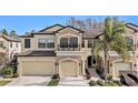 Two-story townhome with two-car garage, balcony, and palm tree at 9236 Fox Sparrow Rd, Tampa, FL 33626