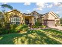 Two-story house with a three car garage, lush landscaping, and stone accents at 1116 Hillandale Reserve Dr, Tampa, FL 33613