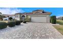 One-story home with tile roof, paver driveway, and lush landscaping at 2003 Captiva Ct, Sun City Center, FL 33573
