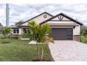 Modern house featuring a paver driveway and palm trees at 2972 Lake Saxon Dr, Land O Lakes, FL 34639