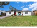 Newly renovated home with a red door and well manicured lawn at 3517 Kingsbury Dr, Holiday, FL 34691