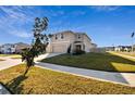 Two-story house with beige exterior, two-car garage, and a large front yard at 38296 Sonnet Landing Ave, Zephyrhills, FL 33540