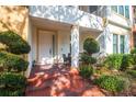 Charming front porch with brick pavers, decorative bushes, and outdoor seating on a covered landing at 4884 Yacht Club Dr, Tampa, FL 33616