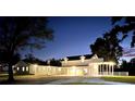 Night view of a charming two-story home with a covered porch and well-lit yard at 724 Bayshore Dr, Terra Ceia, FL 34250