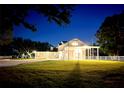 Night view of a spacious farmhouse with a large yard and white fence at 724 Bayshore Dr, Terra Ceia, FL 34250
