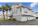 Side view of white two-story condo, showing garage and balcony at 19201 Vista Ln # C8, Indian Shores, FL 33785