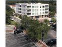 Modern building, ample parking, and lush green surroundings at 231 2Nd S St # 203, Safety Harbor, FL 34695