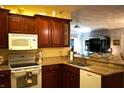 Kitchen with wooden cabinets, granite countertops, and white appliances at 2320 Marksmen Ct # 205, Sun City Center, FL 33573