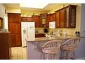Kitchen with wooden cabinets, granite countertops, and white appliances at 2320 Marksmen Ct # 205, Sun City Center, FL 33573