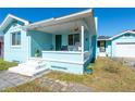 Front porch view of a charming teal house with rocking chairs at 2709 W Cherry St, Tampa, FL 33607