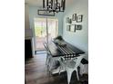 Farmhouse dining area with black table, white chairs, and a view to a screened porch at 3628 Dellefield St, New Port Richey, FL 34655