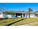 Newly renovated home with white brick exterior, gray roof, and a blue front door at 3946 Doral Dr, Tampa, FL 33634
