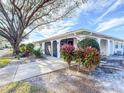 Front view of a single-story home with lush landscaping at 1009 Harefield Cir # 47, Sun City Center, FL 33573