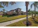 Tan house with palm trees and a sidewalk along the front at 10126 Londonshire Ln, Tampa, FL 33647