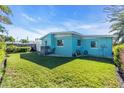 Large grassy backyard with a light teal house at 11435 2Nd E St, Treasure Island, FL 33706