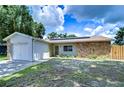 Exterior view of the house showing stone accents and a solar panel system at 11505 Blackbark Dr, Riverview, FL 33579