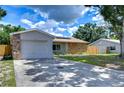 House exterior showcasing a stone facade, attached garage, and landscaping at 11505 Blackbark Dr, Riverview, FL 33579