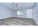 Bright living room with grey walls, wood-look floors, and ceiling fan at 11505 Blackbark Dr, Riverview, FL 33579