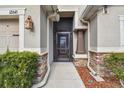 Front entrance with stone accents and a screen door at 12645 Flatwood Creek Dr, Gibsonton, FL 33534