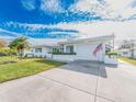 White brick house with teal shutters, a spacious driveway, and a green lawn at 14052 89Th Ave, Seminole, FL 33776