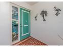 Teal front door with stained-glass sidelight and tropical wall decor at 14052 89Th Ave, Seminole, FL 33776