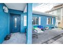 View of the front entrance of a charming blue house with a dark blue door and white shutters at 17744 1St E St, Redington Shores, FL 33708