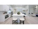 Spacious kitchen featuring white cabinets, a large island, and stainless steel appliances at 2111 Climbing Ivy Dr, Tampa, FL 33618