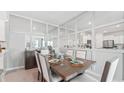 Dining room with a wooden table, white chairs, and a mirrored accent wall at 32691 Rustic Rise Rd, San Antonio, FL 33576