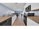 Modern kitchen with long countertop, stainless steel appliances, and tile floors at 34104 White Fountain Ct, Wesley Chapel, FL 33545