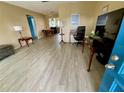 Living room with light gray vinyl flooring, and a view into dining area at 3425 96Th N Ter # 4, Pinellas Park, FL 33782