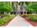 Community building entrance with a paved walkway and lush landscaping at 36750 Us Highway 19 N # 15118, Palm Harbor, FL 34684