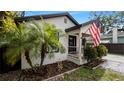 Updated home with a white exterior, black accents, and nicely landscaped yard at 7209 N Highland Ave, Tampa, FL 33604