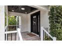 Modern front entrance with a black door, gray tile flooring, and white railings at 7209 N Highland Ave, Tampa, FL 33604