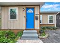 Inviting home exterior with a bright blue door and well-maintained landscaping at 1230 32Nd N St, St Petersburg, FL 33713