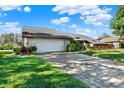 Landscaped yard and a large paved driveway leading to a two-car garage at 14216 Banbury Way, Tampa, FL 33624